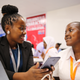 Carolyne Ekyarisiima inspecting the mobile app developed by one of the young coders at the Entrepreneurship Summit.
